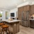 Simi Valley, CA Apartments - Kitchen With Wood-Inspired Flooring, Quartz Countertops, Breakfast Bar, Tile Backsplash, Stainless Steel Appliances, Dishwasher, Wood-Inspired Cabinets, And Access To Living Room.
